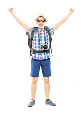 Canvas Print - Smiling male hiker with raised hands gesturing happiness