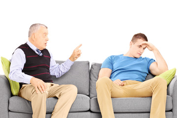 Wall Mural - Father reprimending his son seated on a modern sofa