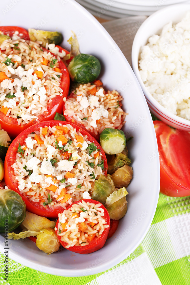 Stuffed tomatoes in bowl on wooden table close-up