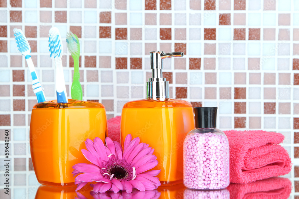 Cosmetics and bath accessories on mosaic tiles background