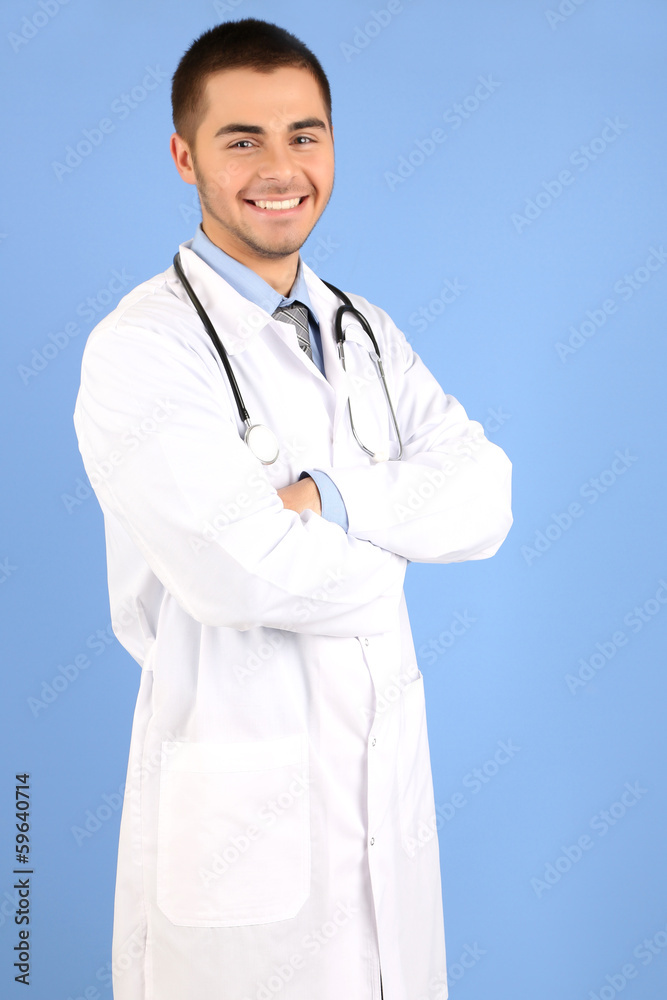 Male Doctor standing with folder, on blue background