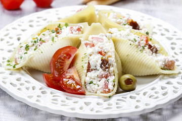 Wall Mural - Italian cuisine: stuffed pasta shells on white plate.