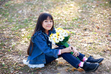 Wall Mural - Young asian girl holding flowers