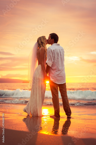 Foto-Leinwand ohne Rahmen - Just married couple kissing on tropical beach at sunset (von EpicStockMedia)