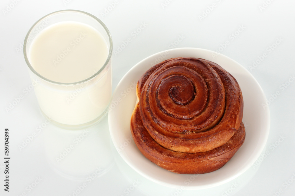 Bread roll and glass of milk isolated on white