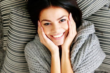 Canvas Print - young smiling woman lying on the floor with pillows