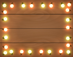 Wall Mural - christmas lights on wooden background, frame with garlands