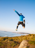 Fototapeta  - Man giving a big jump and practicing trail running