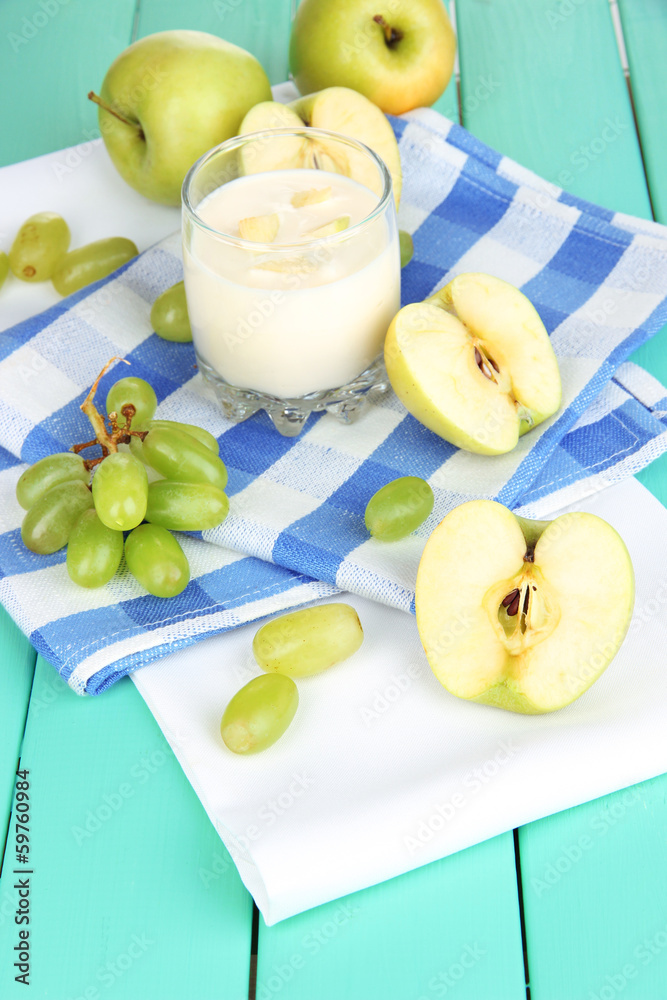 Delicious yogurt in glass with fruit on wooden table close-up