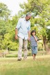 © WavebreakmediaMicro - Grandfather and son walking on grass in park