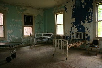 delapidated hospital building with empty rusted beds