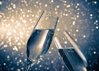 champagne flutes with bubbles on blue light bokeh background