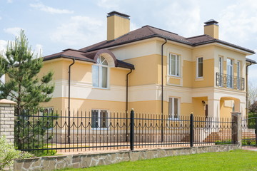 Modern two storey cottage with a wrought fence