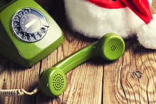 Vintage Phone With Santa's Hat On Wooden Background