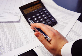 Office table with calculator, pen and accounting document