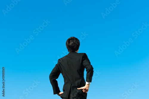 やる気を出す男性ビジネスマンの後ろ姿と青空 Stock Photo Adobe Stock