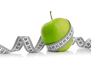 Measuring tape wrapped around a green apple