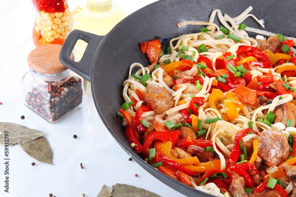Noodles with vegetables on wok isolated on white