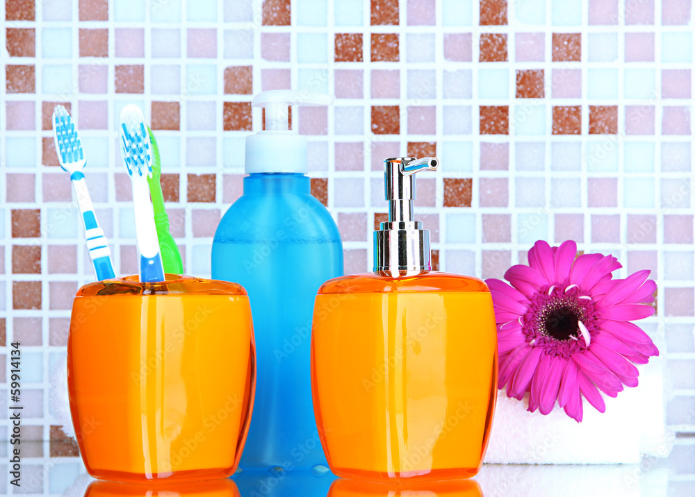 Cosmetics and bath accessories on mosaic tiles background