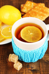 Fototapete - Cup of tea with lemon on wooden table