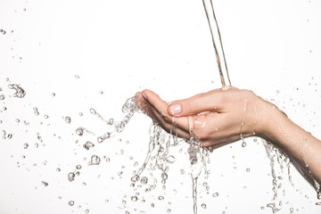 Closeup female hands under the stream of splashing water