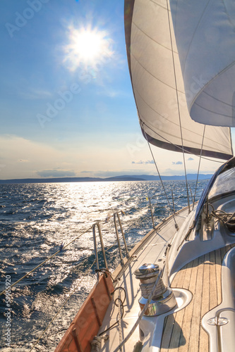 Nowoczesny obraz na płótnie Yacht sailing towards sunset on blue sea