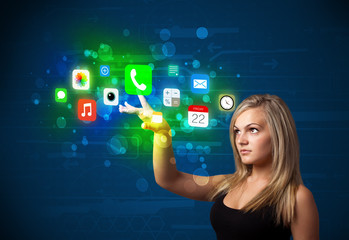 young businesswoman pressing colorful mobile app icons with boke