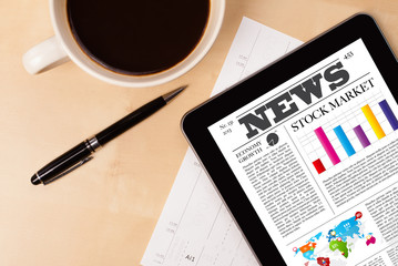 Wall Mural - tablet pc shows news on screen with a cup of coffee on a desk