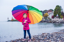Portrait Of A Cute Little Girl With Big Colorful Umbrella