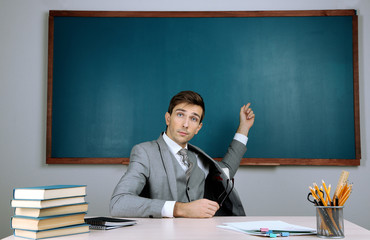 Canvas Print - Young teacher sitting in school classroom