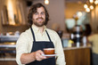 Confident Waiter Holding Coffee Cup In Cafe