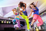 young women in sport dress jumping at an aerobic and zumba exerc
