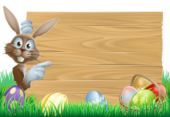 Wall Mural - Easter bunny pointing at sign