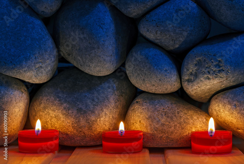 Fototapeta na wymiar Candles are lit on the background of the sauna stones. Preparing
