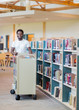 © Tyler Olson - Librarian With Trolley Of Books In Bookstore