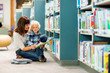 © Tyler Olson - Boy With Teacher Reading Book In Library