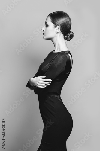 Naklejka ścienna beautiful woman model posing in elegant dress in the studio