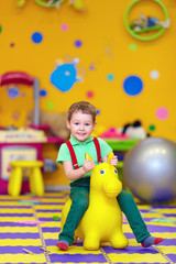 Wall Mural - happy kid riding a toy in kindergarten