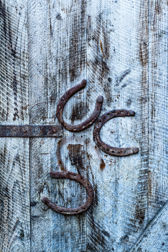 Obraz w ramie rusty horseshoes on a wooden old door, background