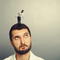 Poster - amazed man looking up at small man