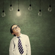 © Creativa Images - Cute little businessman looking at lit bulb
