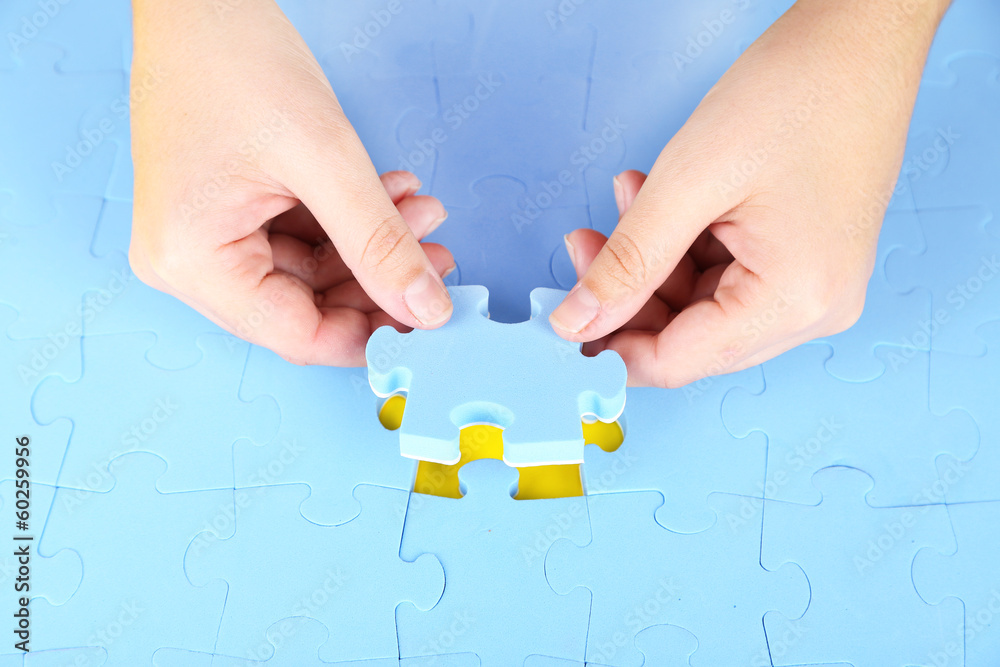 Hand holding puzzle piece, close up