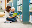 © Tyler Olson - Boy And Teacher Reading Book By Bookshelf