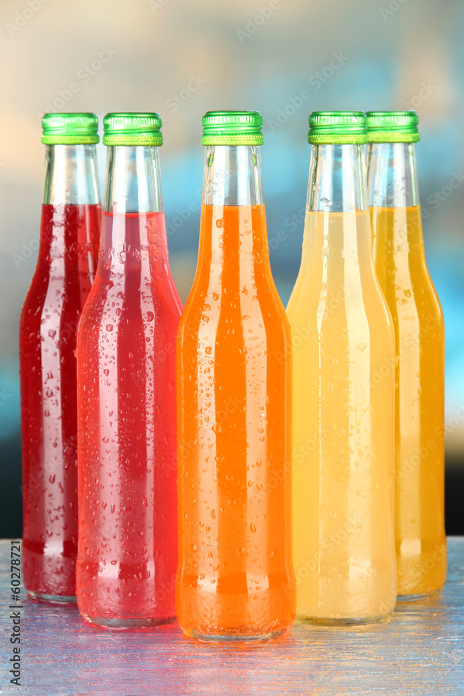Bottles with tasty drinks on bright background
