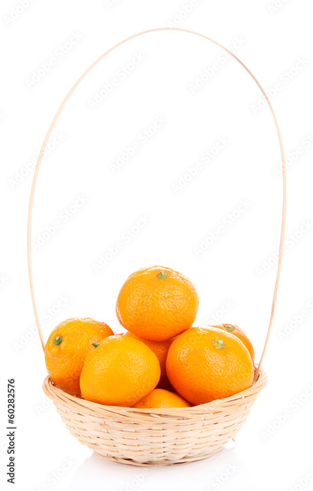 Ripe sweet tangerines in wicker basket, isolated on white