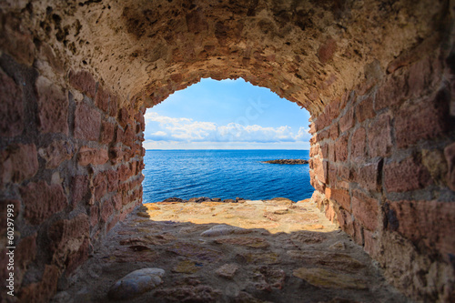 Naklejka - mata magnetyczna na lodówkę Blue sea seascape from hole window frame in old stone wall