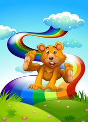 Wall Mural - A hilltop with a playful bear near the rainbow