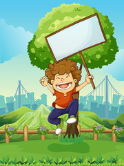 Canvas Print - A happy boy jumping while holding an empty signboard