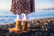 Closeup of legs of a little girl in cozy fur boots background