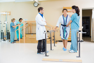 Sticker - Physical Therapists Assisting Female Patient In Walking